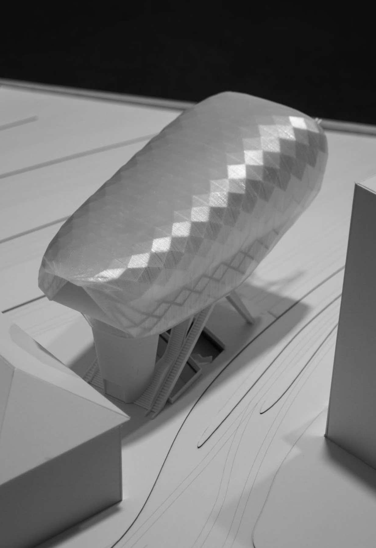 Aerial physical model view of the cable car station roof shell and surrounding urban blocks.
