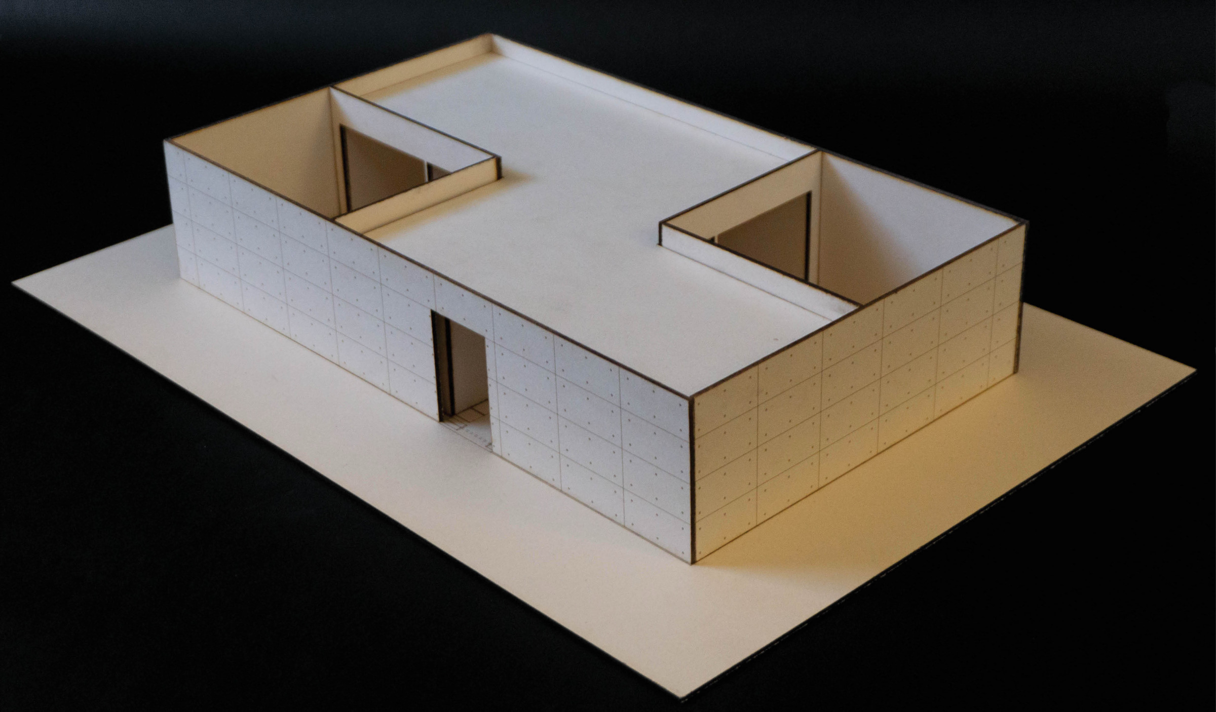 Close view of a physical courtyard house model with rooms organized around open courtyards.